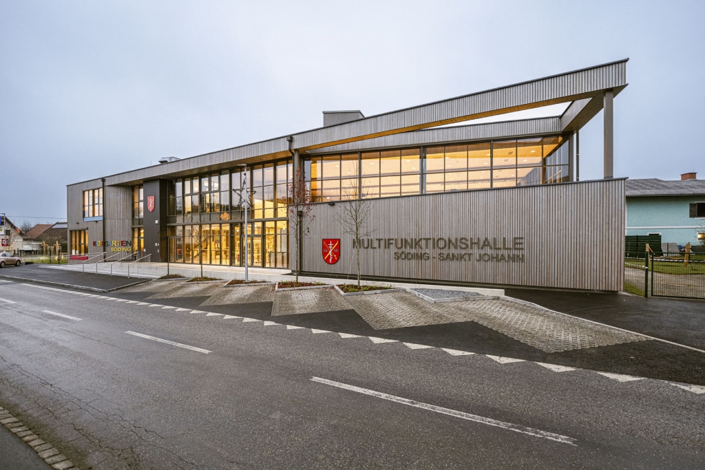 Söding-MZH-6300, Multifunktionshalle und KiGa Kindergarten, Ansicht Eingangsbereich mit Abendstimmung schräg von vorne links, ARTiVO Söding-MZH-6300, Multifunktionshalle und KiGa Kindergarten, Ansicht Eingangsbereich mit Abendstimmung schräg von vorne links, ARTiVO